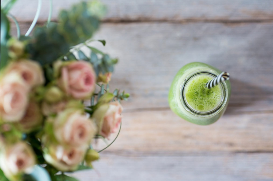 rosas en mesa con smoothie verde